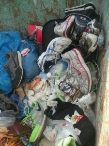 Eine alte Sporttasche voll mit Laufschuhen; - jetzt auf der Deponie!