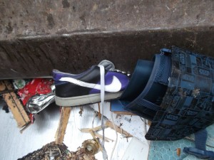 weichgelatschte Teenie-Turnschuhe unter einem stahlharten Pressschild.
