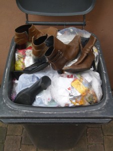 Die Mülltonne war schon so voll, dass Martina die ungewollten Schuhe gar nicht in den Müll werfen konnte, sondern sie stellte sie regelrecht oben drauf.