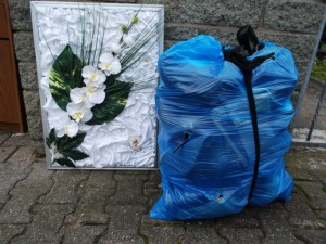 Sie schleppte einen schweren prall gefüllten blauen Müllsack aus dem Haus und war sichtlich froh, ihrem Müll gleich los zu sein, denn die Müllmänner waren schon an ihrem Haus angelangt.