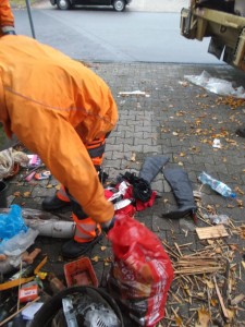 Während die Möbel gerade zermalmt werden, müssen nun die Müllmänner das Kleingerümpel mühsam zusammentragen.