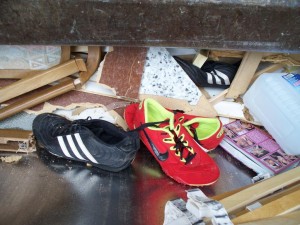 Der eine schwarze Sneaker war schon tief zwischen zermalmten Möbelteilen eingeklemmt.